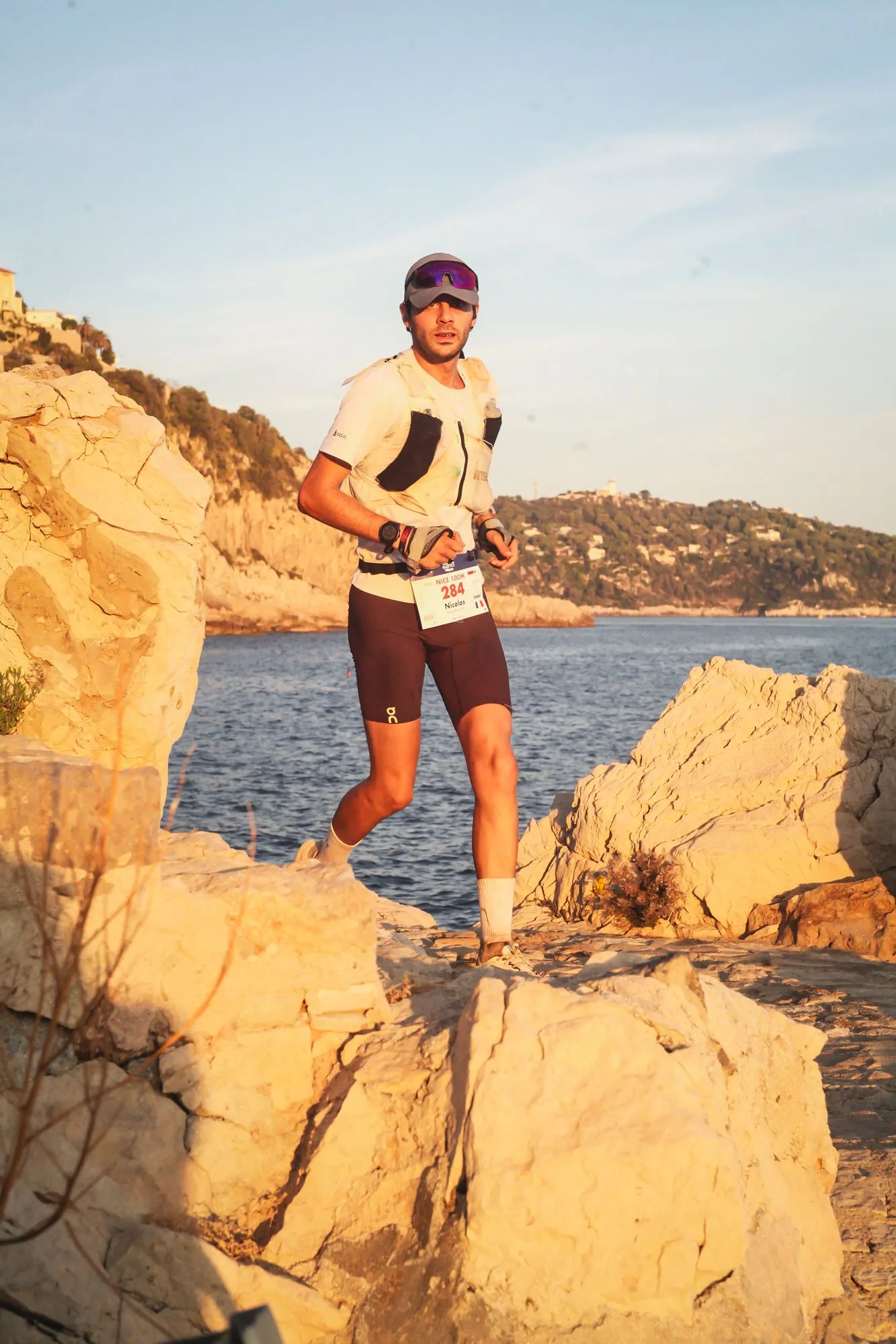 Nicolas Goullet de Rugy court sur les rochers du littoral au coucher du soleil, dans les derniers kilomètres de l’UTMB Nice
