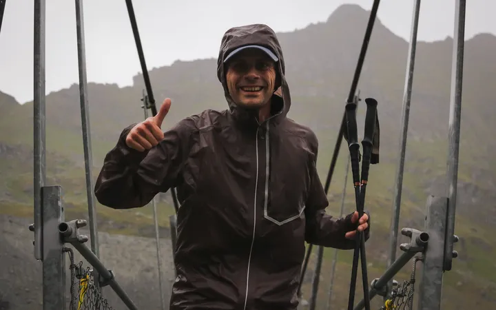 Nicolas Goullet de Rugy sous la pluie sur une passerelle de l’UTMB Verbier, ses bâtons Kiprun carbone à la main